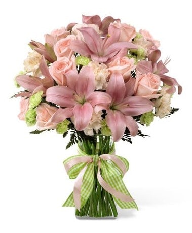ink roses, pink Asiatic lilies, pale carnations, green mini carnations and lush greens are exquisitely arranged in a clear glass vase.