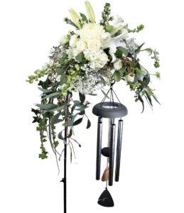 windchime with hook and beautiful white and greenn flowers hanging over it